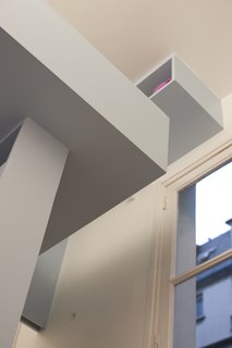 The geometric lines and muted blue color of the inserted architecture make the space feel cleanly divided without cluttering the space with extraneous design flourishes and decorations. Its Lego-like appearance from below helps keep the project from becoming overwhelmingly monolithic while also making it whimsically kid friendly.