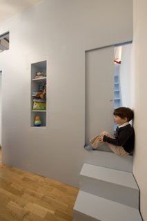 Eva illustrates how the sliding door can be pulled shut to divide her brother's sleeping space at the bottom of the stairs from her bed at the top.