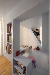 For additional storage, the floor of the partition (shown here beneath the pink stool) easily opens to reveal additional storage space below.