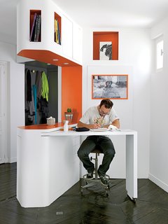 In a 21st-century homage to both the compartmentalization of Hausmann-era interiors and graphic novels, the apartment features dozens of boxy shelves, highlighted by saturated colors. The motif also optimizes the small space as a drawing table folds away to reveal a shoe closet.