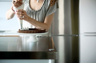 Reflected in the Bulthaup System 20’s gleaming stainless steel surface, Chelsea uses a pastry bag to pipe the marshmallow kisses onto her s’mores tart.