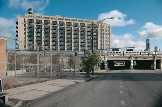 With SOM’s Willis Tower looming in the background, a double-decker Metra train passes by the University Station building, a former produce storage facility in Chicago’s Pilsen neighborhood.