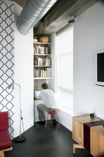 Arthur installed shelving from Ikea and poured a cast-in-place concrete shelf to create a small media nook.