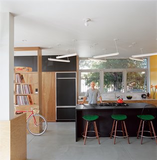 The "murdered kitchen" includes a fluorescent light sculpture with dimmable ballasts designed by Bestor. The rough plywood offers a nice chromatic contrast.