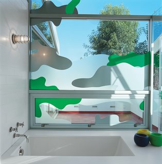 Los Angeles–based graphic designer Chris Loomis created a trio of window decals for the house’s three bathrooms. Grunbaum went with a camouflage pattern for privacy in the master bathroom, which has a wall of floor-to-ceiling glass that looks onto an adjacent patio. "Because we’re sort of in the trees, I wanted to keep the plant theme going," he says. laloomis.com
