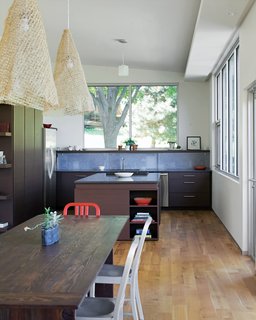 The dining table was made from reclaimed pine that Julie refinished with layers of stain and wax. Julie also made the lamps, using Knoll textiles.