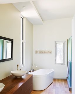 The Duravit tub in the master bathroom is another favorite spot for keeping warm; it offers a slender view out toward the trees.
