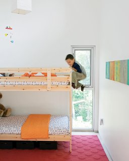 In the kids’ room, Jack climbs the bunk bed he shares with his little brother, James. The paintings on the wall were done by their mom.