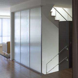 Glass panels surrounding the stairwell allow a nice amount of gentle light into the living room. Photo by Mark Darley.