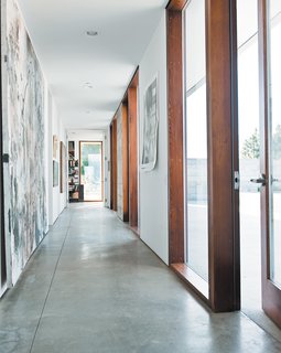 The long hallway leading to the bedrooms gets spectacular afternoon sun, lighting up the family’s many works of art.