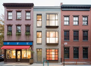 Even with the reused truck bodies creating large windows in the facade, the house still cuts a trim figure on the street. The rooftop garden is hidden from the sidewalk.