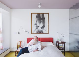 Lawrence relaxes in the master bedroom with a hand-rolled cigarette. The room has a lavender ceiling (Alice was told it’s the best color to see when waking).