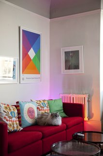 In the living room, the LivingColors lamp, though obscured from view by a Knoll sofa by Charles Pfister, mimics the bright warm tones of the Max Bill poster. Grawe's cat, Eero, settles in amongst a collection of both vintage and contemporary pillows.