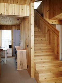 Knotty by Nature - Photo 14 of 25 - The knot-flecked staircase leading down to Bornstein's office gives serves as a solid core to the home's circulation.