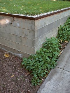 How Good Idea Studio Revamped a 1924 Clapboard House on a $62,000 Budget - Photo 11 of 11 - Concrete retaining walls form an outdoor terrace that serves as a dining area, conference room, and workshop. The three-quarter-inch construction gravel from George L. Throop Company allows rain to percolate into the ground and irrigate a lemon tree rather than create polluting runoff.