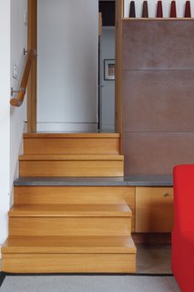 From Brown to Green - Photo 2 of 8 - A staircase leads up to the main bedroom; the stairs and the fireplace were designed by Fleming with the architects.