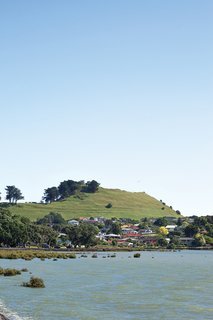 Auckland’s Mangere Mountain is a dormant volcano that rises above the shore of the Manukau Harbor. It was once a site of strategic importance to early Maori tribes, and development is now prohibited on its cone.