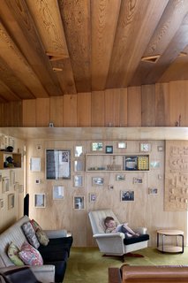 Four-year-old Seamus relaxes in the living room, whose plywood walls <br><br>are covered with family photographs.