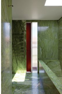 The tiny budget still allowed room for some strategic splurges, such as the vivid green Verde Ming marble in the house’s only bathroom.