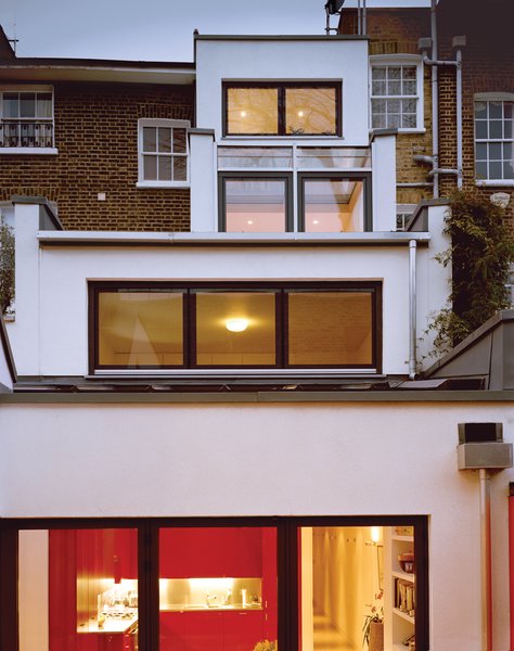 At the back, the building steps down to the courtyard garden in a ziggurat formation, with the main living spaces on the lowest floor.