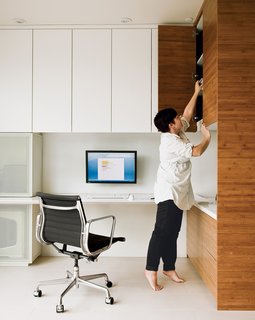 Lucky 7 - Photo 1 of 15 - An Eames Aluminum Group chair for Herman Miller and bamboo shelving system are featured in the office Camille Owens and architect husband Francisco created within their living-dining space.