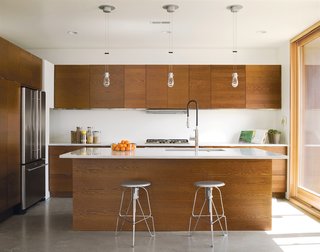 The family's 150-square foot kitchen features Carrara marble countertops—perfect of pasta-making, John says. The stools are the Covey Stools by Jeff Covey.