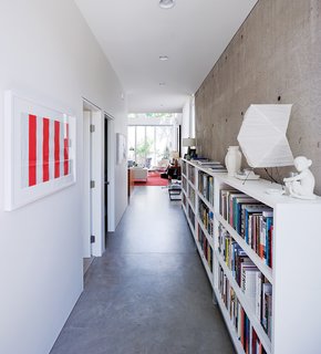 A portion of Blauvelt’s 3,000-book library is archived in the long entry hall where the geometry of a Noguchi lamp plays off a pair of minimalist prints by Daniel Buren.