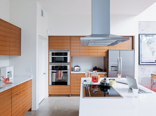 The kitchen features cabinets by carpenter James LaChance, Hanstone quartz countertops, Electrolux Icon Series appliances, and a Jenn-Air exhaust hood.