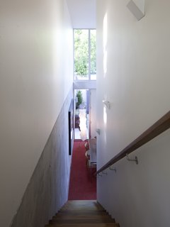 The sight line down the stairs leads right past the dining room table and out toward the coutyard.