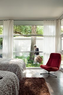 The guest room has one of the most enviable views of the pecan tree as well as the shed out back. Susan tends the ground cover. The Lunna swivel chair is from Ikea.