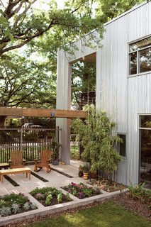 Though much of the outdoor life of the house is within the confines of the yard, the design has a porousness that allows a perpetual, if mediated, interaction with the neighbors and the street.