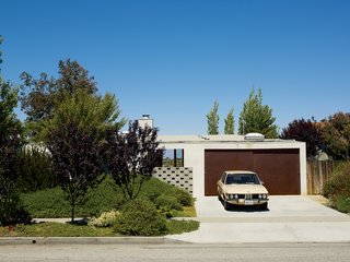 How a Bungalow Went from Bland to Brilliant - Photo 1 of 9 - Streetside, foliage and a concrete wall by artist Evan Holloway camouflages Anthony Pearson and Ramona Trent’s low-key Mar Vista home.