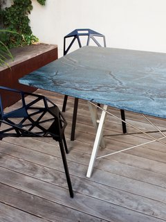 Can't find the right table for your space? Another option is to have a custom top cut for a recycled base, which is what the Deams did for their outdoor dining area. They had an existing Scissor table base by Bay Area designer John Randolph sitting unused, so Chris had a piece of hardy soapstone (it stands up to high temperatures) cut to match by Fox Marble. A subtle facet at each corner plays off the base's design and lends a more intimate feel to the long table. For a fraction of the cost of a full piece, the bases of design classics are often available on Craigslist and eBay.