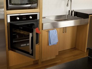 The Kohler faucet was mounted on the side of the custom sink rather than at the back, and the tip detaches and extends from the base for better ease of use. The oven, from Fagor, "was the only side-opening oven of the right size we could find," says Sundstrom. The tile is from Ann Sacks.