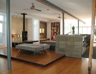 Triangle House Tours - Photo 15 of 30 - A floating platform defines the living zone and a concrete block wall surrounds a new commercial kitchen (a reference to the old store’s huge penny candy counter).