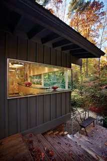 Triangle House Tours - Photo 26 of 30 - The house is transformed by inserting a minimalist glass corner into the kitchen. This single move creates a sculptural statement that becomes a foreground element and allows the rest of the house to become background to the glass form.