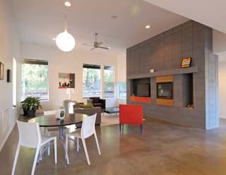 Triangle House Tours - Photo 30 of 30 - A concrete block hearth serves as the focus of the main living area as well as the delineation of the main entrance.