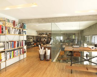 On the second floor, Larissa's office space looks over the workshop via a 20-foot-tall glass-enclosed shaft that lets lights in and accommodates behemoth projects.