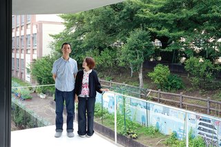Without a garden of their own, Takuya and Yurika enjoy the verdant view of the schoolyard cherry trees next door from their bedroom balcony.