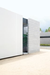 The exterior of the house consists of sandblasted masonry and Ferrari shade sails stretched on a steel frame.