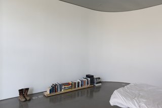 Keener's bedroom contains a bed, a pair of boots, and a selection of books—and nothing else.