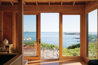 The deck off the front is also minimally furnished with elegant lines of beach rock and two Leaf chairs by Arper.