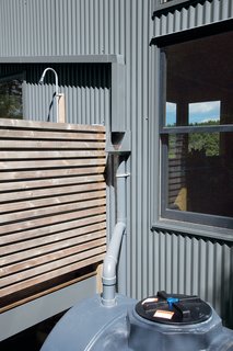 The rain-catchment system next to the outdoor shower collects and disposes of the first five gallons of rainwater to ensure that the cleanest water is diverted into the cistern.