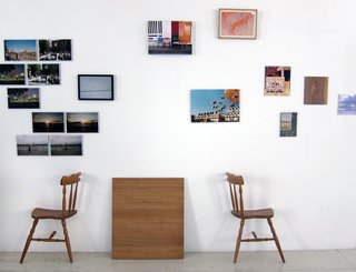 Khemsurov: "One of the living room walls hosts a makeshift art installation consisting of photos the pair took on a recent trip to New York, photos from past projects, gifts from friends, and in the upper right corner, their first art purchase — it's part of an art workshop a friend conducted with children in Africa. The chair halves were part of Seng's diploma project at school."