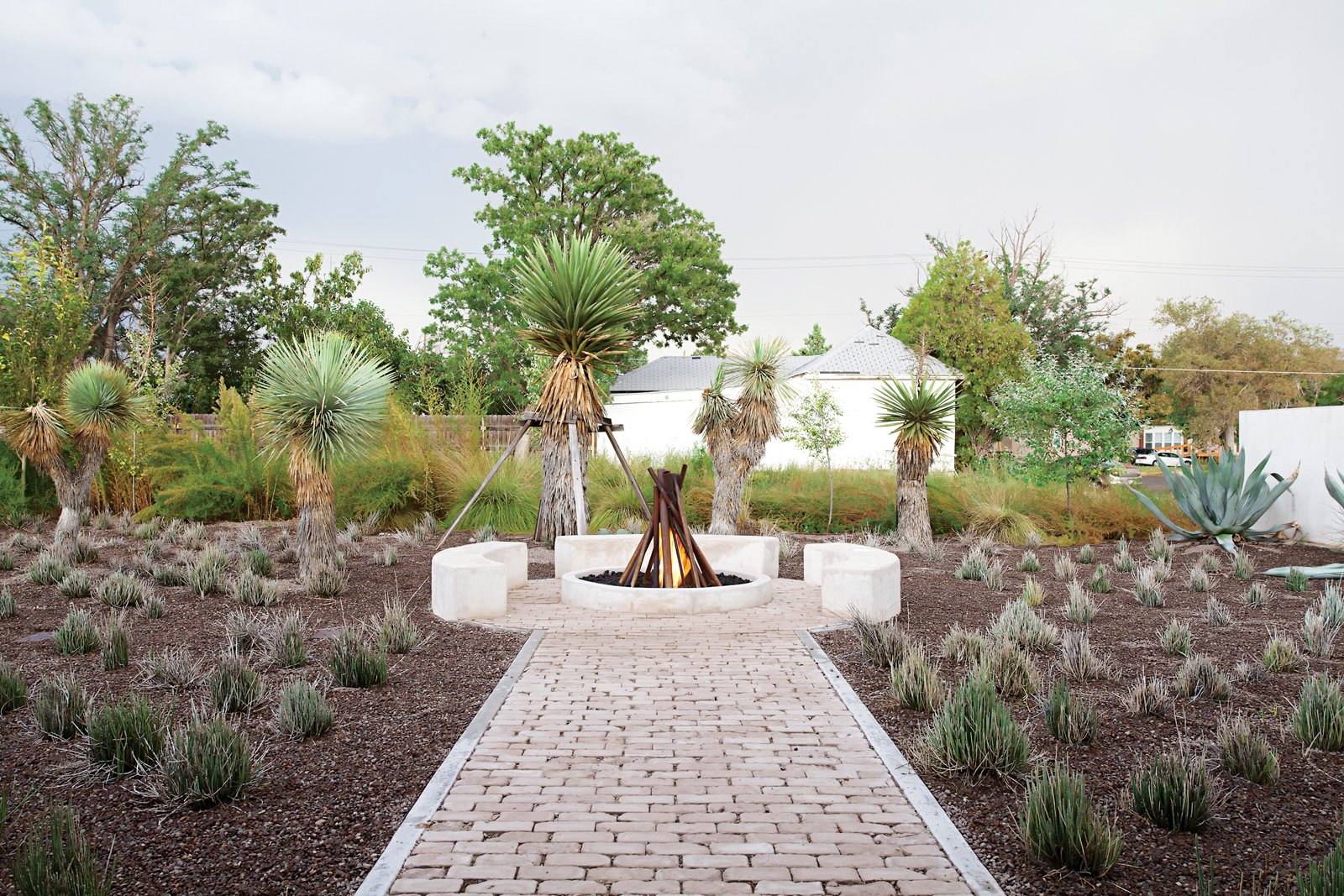 Hill worked with metal artist and designer George Sacaris to create a sculptural gas fire pit in her backyard. Using repurposed pipes uncovered during the renovation, Sacaris welded them together in a vertical formation. When the fire is flickering, it engulfs the sculpture and adds another note of drama to the outdoor area.