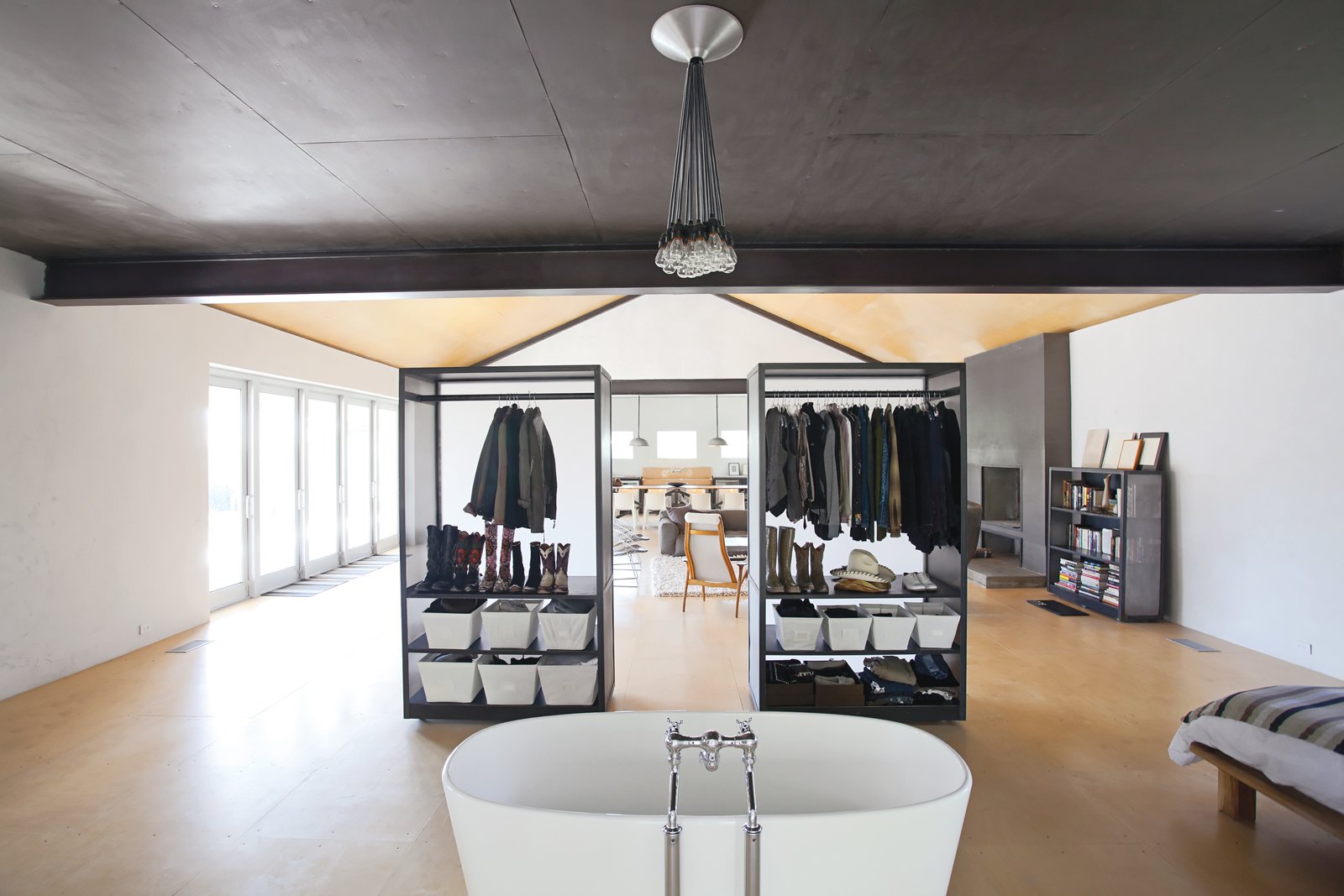 Hill's custom closets do double duty as both clothing receptacles and movable partitions, thanks to skateboard wheels affixed to their bases. Substantial enough to create a visual barrier but translucent to allow light through. the closets are backed by panels of formerly glossy white Plexiglas that Hill asked Sacaris to rough up with a piece of sandpaper.