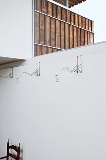 Looking for a creative way to light Blans's painting collection, the architects collected old, broken umbrellas from Utrecht residents, and transformed them into whimsical and adjustable halogen lamps that latch onto the interior walls.