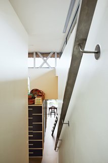 The steel frame of the house was entirely recycled from mill machinery formerly employed in the region's textile industry, which has since declined. Leaving the steel skeleton visible in places, as here, makes a tangible link with local history.