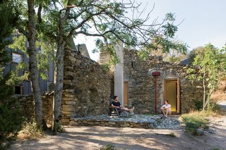"We really wanted to capture the ruinous quality of this old building rather than do something overtly new," Blee says. Before construction could begin, however, he and Halligan had to patch the remaining walls using stones found in the nearby river. Wherever a wall had collapsed, the designers inserted framing to create windows and doors. For the roof, they turned to the original tiles. "My father's terrible at throwing things away," Blee says. "We took the tiles off 30 years ago, as it was too dangerous to have them up there. They've been sitting in the fields ever since, and this was out last chance to use them."