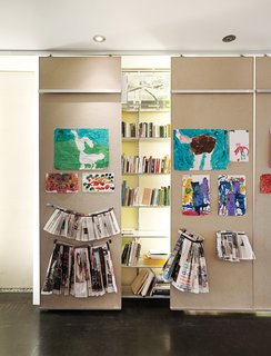 Just Redo It - Photo 3 of 9 - In the ground-floor gallery, 40-foot-long library shelving is punctuated by floor-to-ceiling columns made from white acrylic panels that conceal low-cost fluorescent-tube lighting.